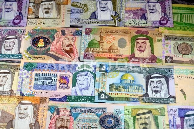 Background of Saudi Arabian riyals SAR banknotes cash money bills, of different ties, eras and values, from old vintage retro King Fahd times till kin