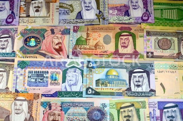 Background of Saudi Arabian riyals SAR banknotes cash money bills, of different ties, eras and values, from old vintage retro King Fahd times till kin