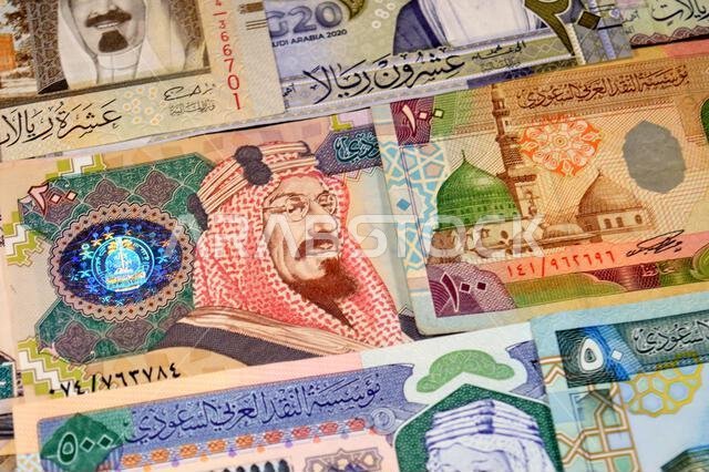 Background of Saudi Arabian riyals SAR banknotes cash money bills, of different ties, eras and values, from old vintage retro King Fahd times till kin