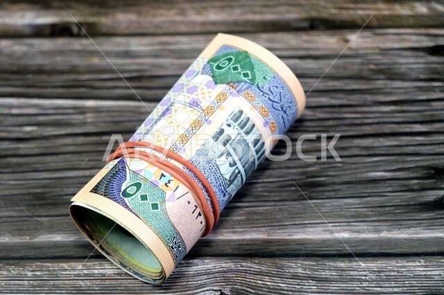 500 SAR five hundred Saudi riyals cash money banknote bills roll wrapped up with elastic rubber, features The Kaaba, inside the Great Mosque of Mecca,