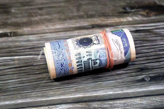 500 SAR five hundred Saudi riyals cash money banknote bills roll wrapped up with elastic rubber, features The Kaaba, inside the Great Mosque of Mecca,