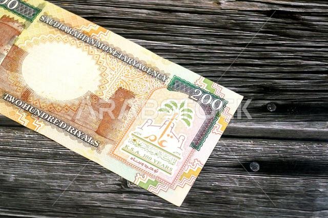 يظهر على الوجه الخلفي للورقة النقدية من فئة 200 ريال سعودي قصر المصمك في المنتصف، وشعار المملكة بمناسبة مرور مئة عام على تأسيسها، وحرف C.
