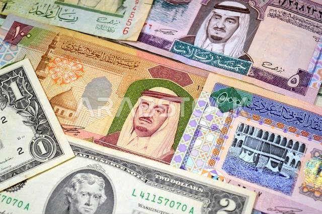عملات ورقية من الدولارات الأمريكية والريال السعودي، من أزمنة وحقب وقيم مختلفة، عملات الريال السعودي والأمريكي