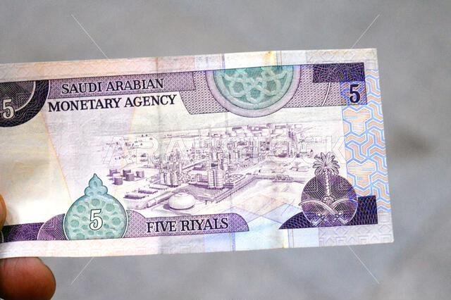 the reverse side of 5 SAR five Saudi Arabian riyals cash money banknote bill, features Oil refinery at center right, old vintage retro Saudi money