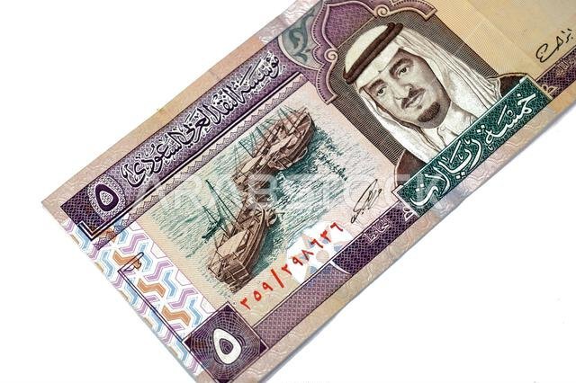 the obverse side of 5 SAR five Saudi Arabian riyals cash money banknote bill, features a portrait of king Fahd Bin AbdulAziz Al Saud and Dhows at lef the obverse side of 5 SAR five Saudi Arabian riyals cash money banknote bill, features a portrait of king Fahd Bin AbdulAziz Al Saud and Dhows at lef