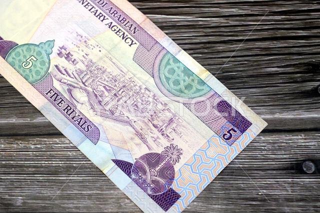 الوجه الخلفي لورقة نقدية من فئة 5 ريالات سعودية، يظهر مصفاة نفط في وسط اليمين، وهي عملة سعودية قديمة الطراز.