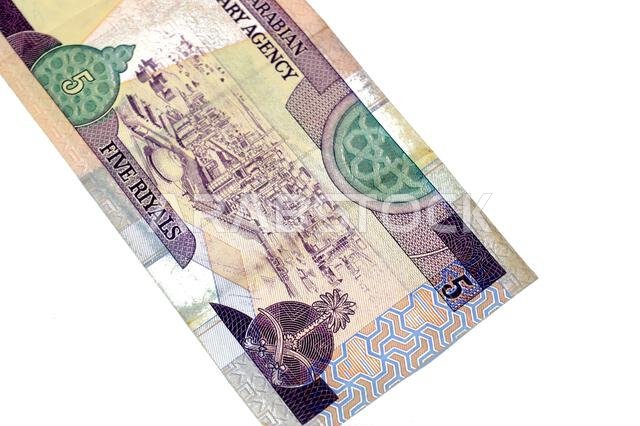 الوجه الخلفي لورقة نقدية من فئة 5 ريالات سعودية، يظهر مصفاة نفط في وسط اليمين، وهي عملة سعودية قديمة الطراز.
