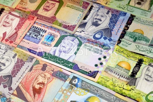 أوراق نقدية من الريال السعودي (SAR) من مختلف العصور والقيم، بدءًا من العملات القديمة ذات الطابع الكلاسيكي في عهد الملك فهد وحتى عهد الملك سلمان.