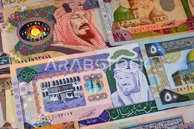 Background of Saudi Arabian riyals SAR banknotes cash money bills, of different ties, eras and values, from old vintage retro King Fahd times till kin