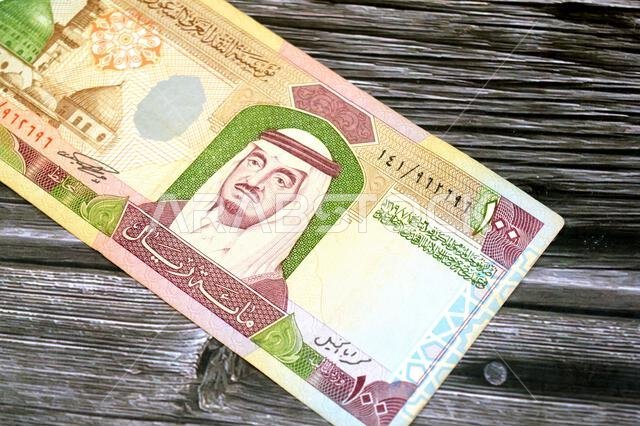 يحتوي الوجه الأمامي للورقة النقدية من فئة 100 ريال سعودي على صورة الملك فهد بن عبد العزيز والنبي.