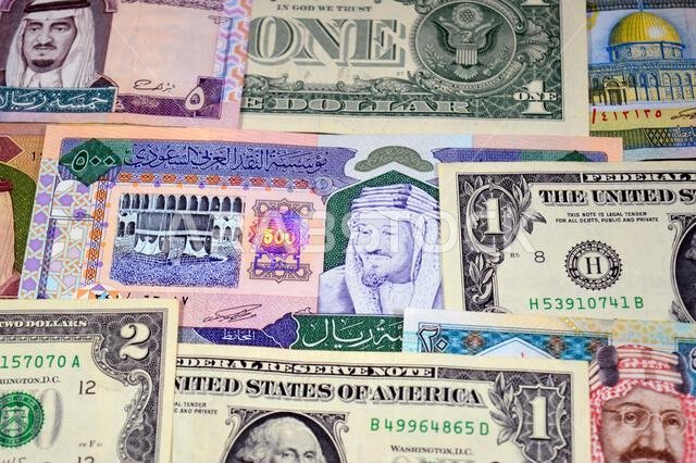 عملات ورقية من الدولارات الأمريكية والريال السعودي، من أزمنة وحقب وقيم مختلفة، عملات الريال السعودي والأمريكي