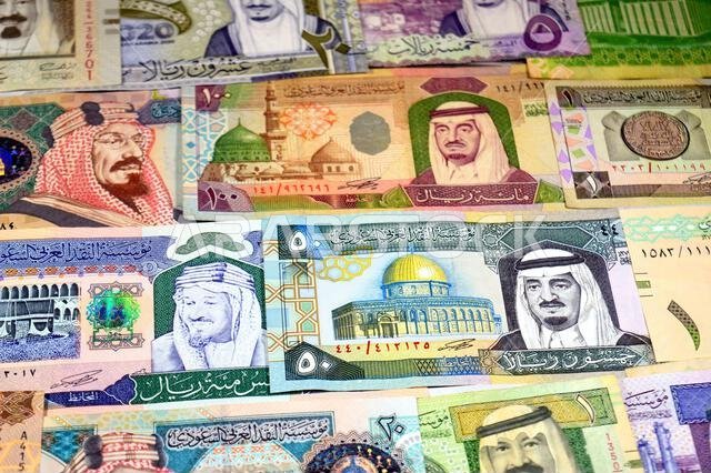 Background of Saudi Arabian riyals SAR banknotes cash money bills, of different ties, eras and values, from old vintage retro King Fahd times till kin Background of Saudi Arabian riyals SAR banknotes cash money bills, of different ties, eras and values, from old vintage retro King Fahd times till kin