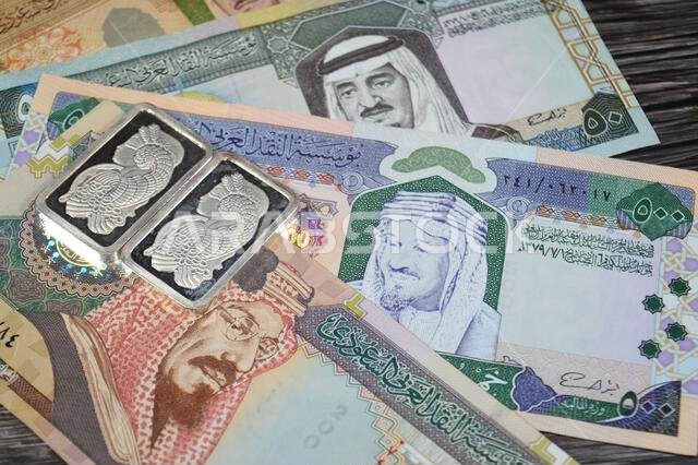 أوراق نقدية قديمة من الريال السعودي وسبائك من الفضة الخالصة وزنها أونصة. يتأثر سعر الفضة بالمضاربة والعرض.