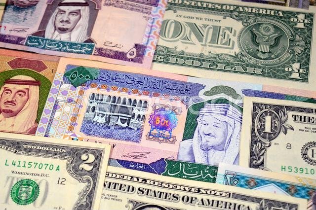 عملات ورقية من الدولارات الأمريكية والريال السعودي، من أزمنة وحقب وقيم مختلفة، عملات الريال السعودي والأمريكي