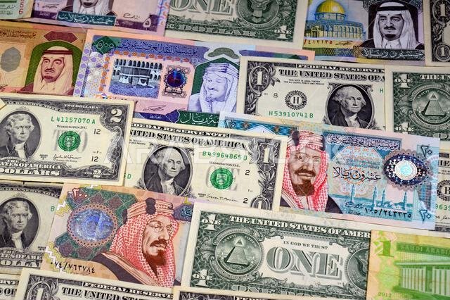 عملات ورقية من الدولارات الأمريكية والريال السعودي، من أزمنة وحقب وقيم مختلفة، عملات الريال السعودي والأمريكي