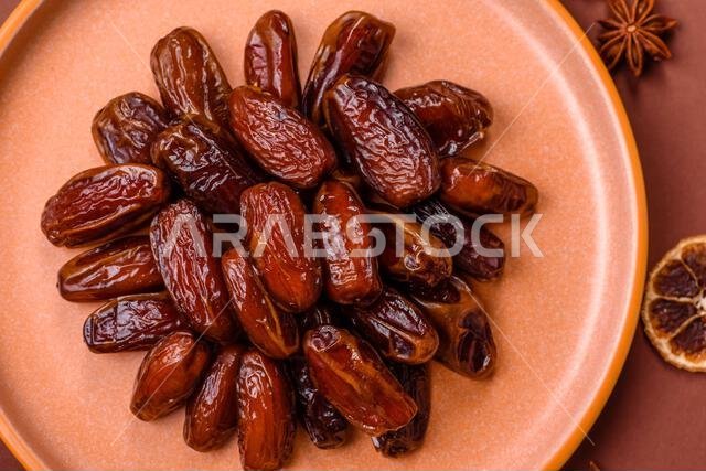 Dried dates in a ceramic plate, arabic food for the ramadan table. Dried dates as a food backdrop for your design.