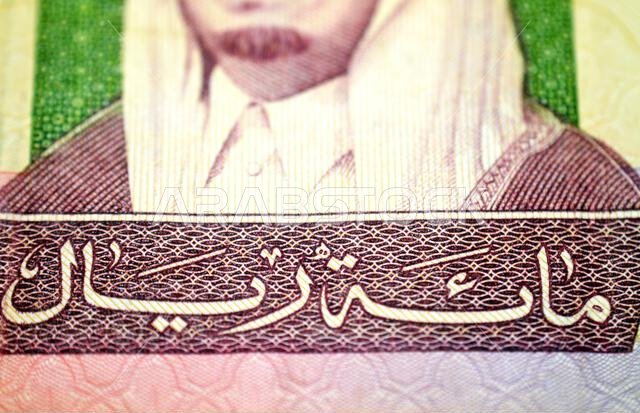 part of obverse side of 100 SAR one hundred Saudi Arabian riyals cash money banknote bill, features a portrait of king Fahd Bin AbdulAziz and the Prop part of obverse side of 100 SAR one hundred Saudi Arabian riyals cash money banknote bill, features a portrait of king Fahd Bin AbdulAziz and the Prop
