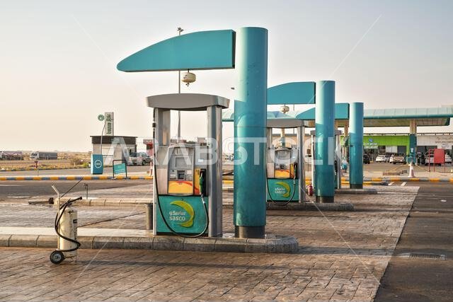 ينبع، المملكة العربية السعودية - 2 مارس 2023: مواقف سيارات فارغة في محطة وقود ساسكو، ومركبات أخرى بالقرب من سوبر ماركت صغير في الخلفية. خدمات السيارات السعودية