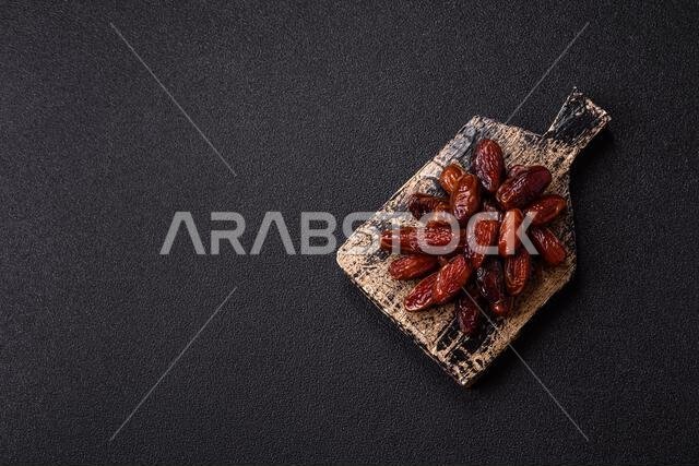 Dried dates in a ceramic plate, arabic food for the ramadan table. Dried dates as a food backdrop for your design.