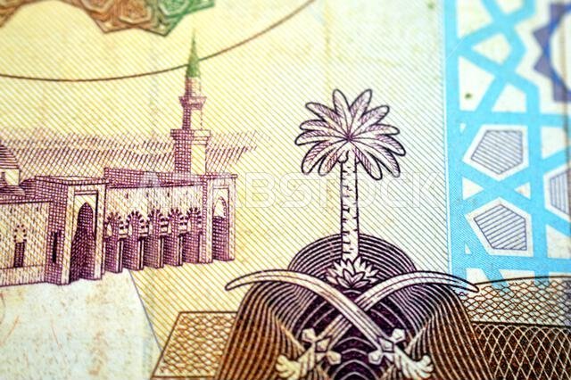 يُظهر جزء من الوجه الخلفي لورقة نقدية من فئة 100 ريال سعودي منظرًا عامًا للمسجد النبوي الشريف في