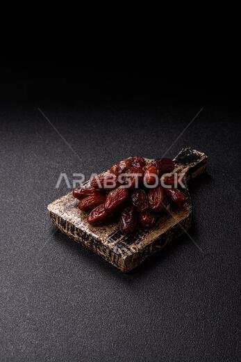Dried dates in a ceramic plate, arabic food for the ramadan table. Dried dates as a food backdrop for your design.