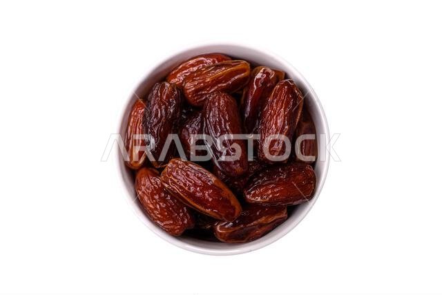 تمر مجفف في طبق خزفي، طعام عربي لمائدة رمضان. التمر المجفف كخلفية طعام لتصميمك.