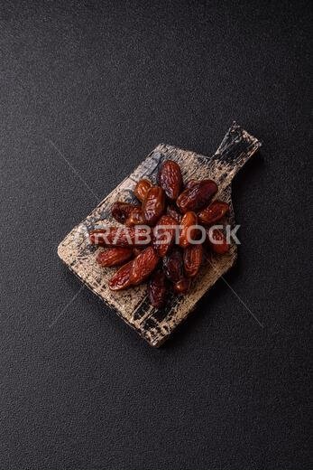 تمر مجفف في طبق خزفي، طعام عربي لمائدة رمضان. التمر المجفف كخلفية طعام لتصميمك.