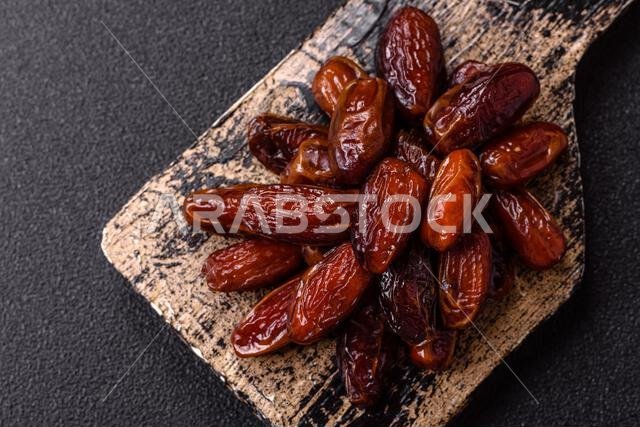 Dried dates in a ceramic plate, arabic food for the ramadan table. Dried dates as a food backdrop for your design.
