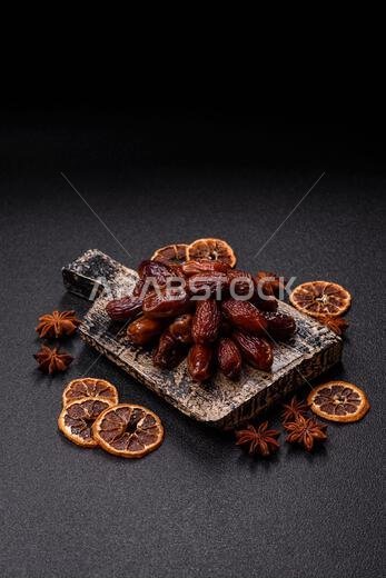 Dried dates in a ceramic plate, arabic food for the ramadan table. Dried dates as a food backdrop for your design. Dried dates in a ceramic plate, arabic food for the ramadan table. Dried dates as a food backdrop for your design.