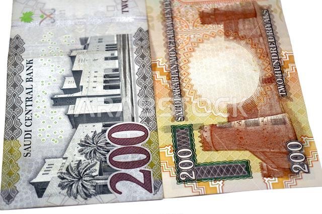 The reverse sides of old and new 200 SAR two hundred Saudi Arabia riyal cash money banknote bill, features Al Masmak Palace and the Qasr Al Hukm in Ri