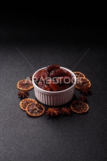 Dried dates in a ceramic plate, arabic food for the ramadan table. Dried dates as a food backdrop for your design.