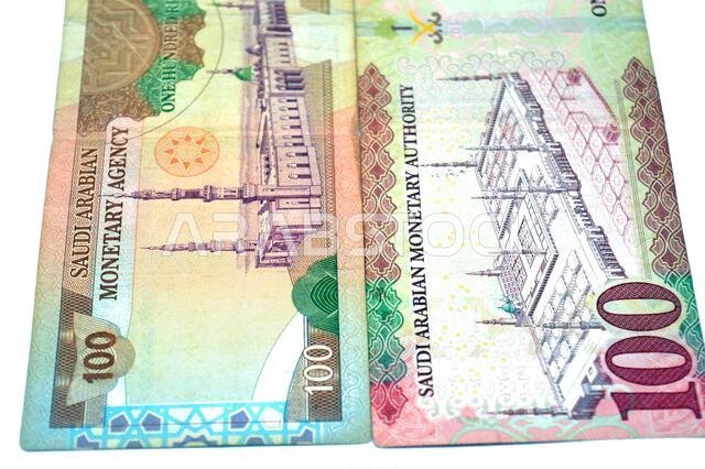 reverse sides of old and new 100 SAR one hundred Saudi Arabian riyals cash money banknote bill, features a general view of the Holy Prophet's Mosque a