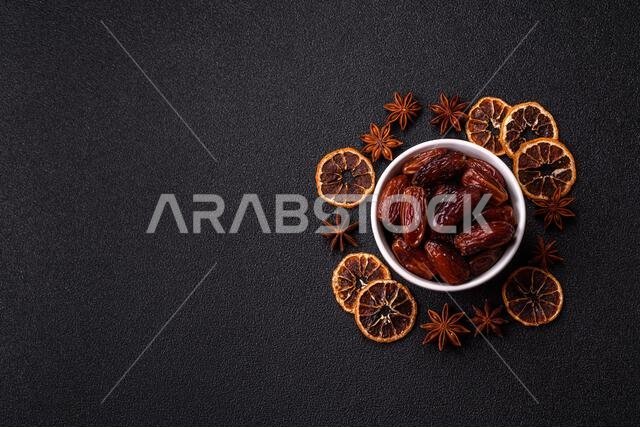 Dried dates in a ceramic plate, arabic food for the ramadan table. Dried dates as a food backdrop for your design.