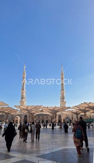 Medina, Saudi Arabia - March 5, 2024:  Pilgrims walk to the main mosque of the Prophet Muhammad Al-Masjid an-Nabawi