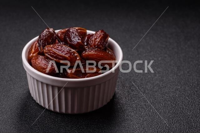 تمر مجفف في طبق خزفي، طعام عربي لمائدة رمضان. التمر المجفف كخلفية طعام لتصميمك.