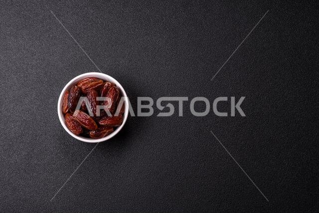 Dried dates in a ceramic plate, arabic food for the ramadan table. Dried dates as a food backdrop for your design.