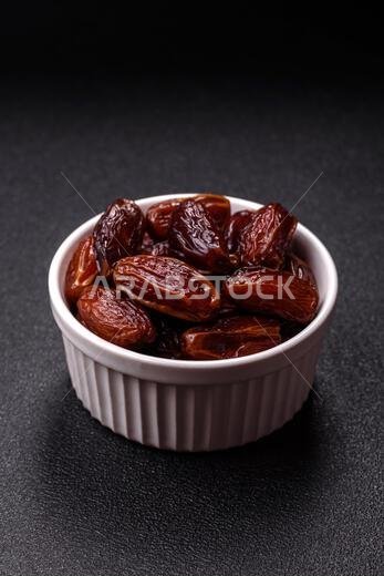 تمر مجفف في طبق خزفي، طعام عربي لمائدة رمضان. التمر المجفف كخلفية طعام لتصميمك.