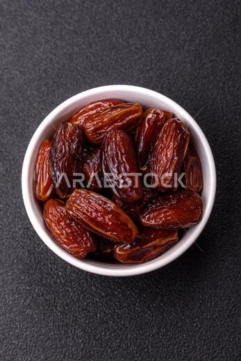 تمر مجفف في طبق خزفي، طعام عربي لمائدة رمضان. التمر المجفف كخلفية طعام لتصميمك.