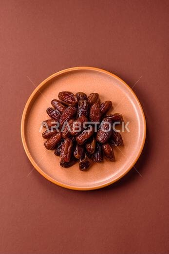 تمر مجفف في طبق خزفي، طعام عربي لمائدة رمضان. التمر المجفف كخلفية طعام لتصميمك.