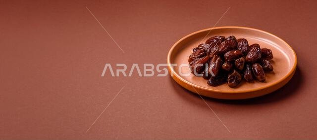 Dried dates in a ceramic plate, arabic food for the ramadan table. Dried dates as a food backdrop for your design.