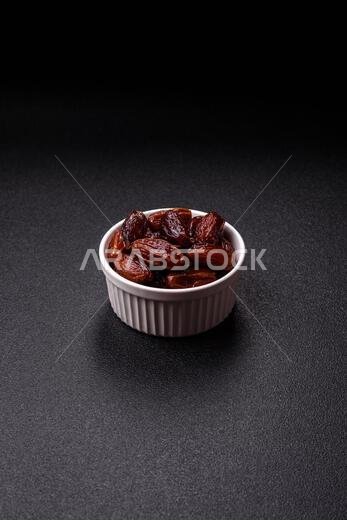 Dried dates in a ceramic plate, arabic food for the ramadan table. Dried dates as a food backdrop for your design.