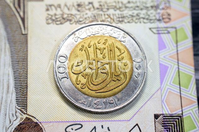 يحتوي الوجه الخلفي لعملة الريال السعودي الواحد (1 ريال سعودي) على القيمة الاسمية، والكتابة، وعبارة "مائة هلالة"، و"ريال واحد 1419"، على تصميم عتيق قديم.