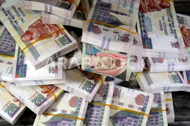 SAR Saudi Arabian riyals and Stacks and piles of Egyptian money of 200 LE EGP two hundred Egyptian pounds cash, by the central bank of Egypt, Egyptian