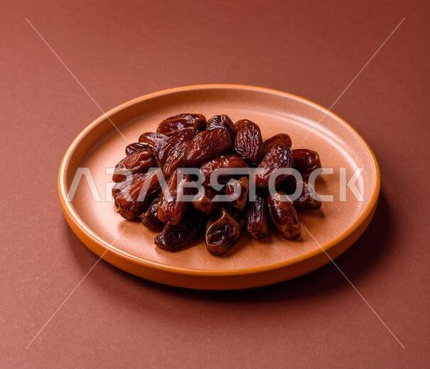 تمر مجفف في طبق خزفي، طعام عربي لمائدة رمضان. التمر المجفف كخلفية طعام لتصميمك.