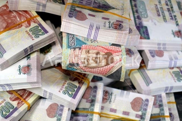 SAR Saudi Arabian riyals and Stacks and piles of Egyptian money of 200 LE EGP two hundred Egyptian pounds cash, by the central bank of Egypt, Egyptian