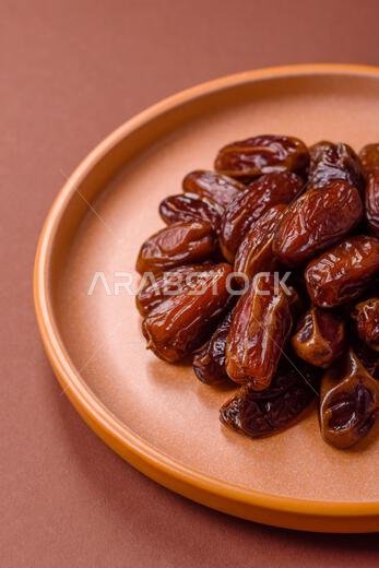 تمر مجفف في طبق خزفي، طعام عربي لمائدة رمضان. التمر المجفف كخلفية طعام لتصميمك.
