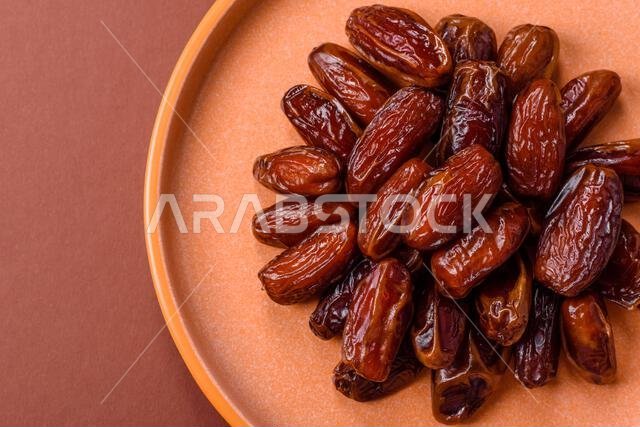 تمر مجفف في طبق خزفي، طعام عربي لمائدة رمضان. التمر المجفف كخلفية طعام لتصميمك.