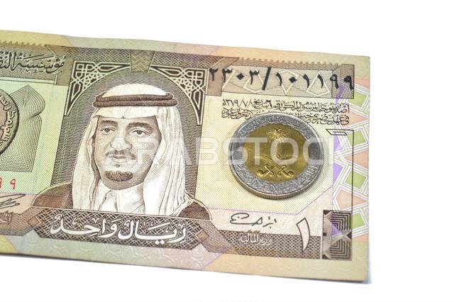 يحمل وجه العملة المعدنية من فئة ريال سعودي واحد (1 ريال سعودي) الشعار الوطني في المنتصف، مع كتابة "خادم الحرمين الشريفين" حوله.