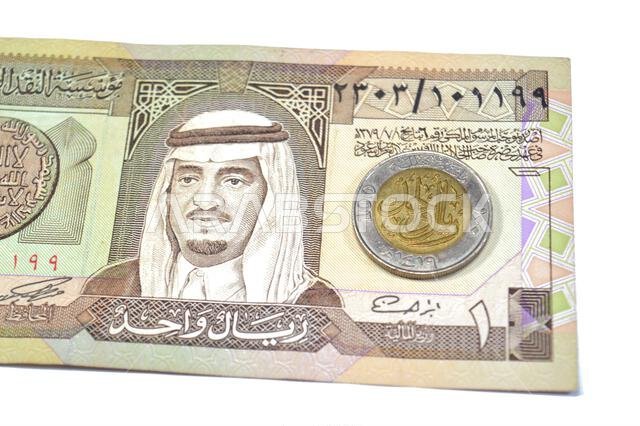 The reverse side of 1 SAR one Saudi Arabian Riyal coin features Denomination, Lettering, One Hundred Halalah, One Riyal 1419, on an old vintage retro