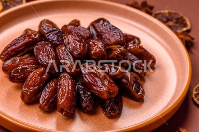 تمر مجفف في طبق خزفي، طعام عربي لمائدة رمضان. التمر المجفف كخلفية طعام لتصميمك.
